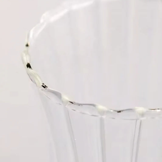 Erkugo'nun Ehlikeyf Çay Bardağı'nın, hafif tırtıklı kenarıyla birlikte berrak nervürlü borosilikat kamının yakın çekimi. Yumuşak, nötr arka plan, zarif tasarımını ve olağanüstü termal şok direncini vurgular.